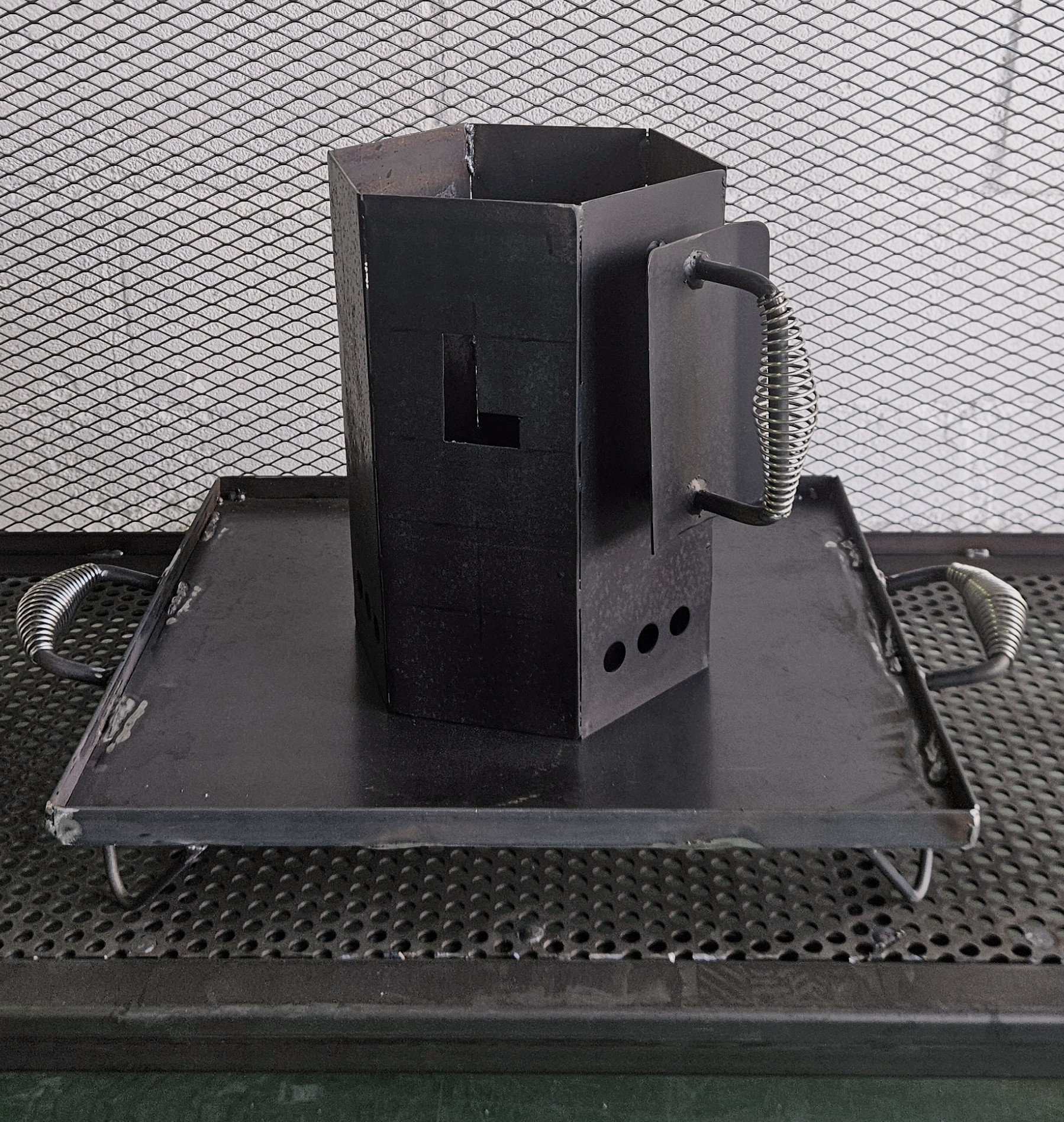 Encendedor de carbón hexagonal de acero al carbono sobre plataforma de acero