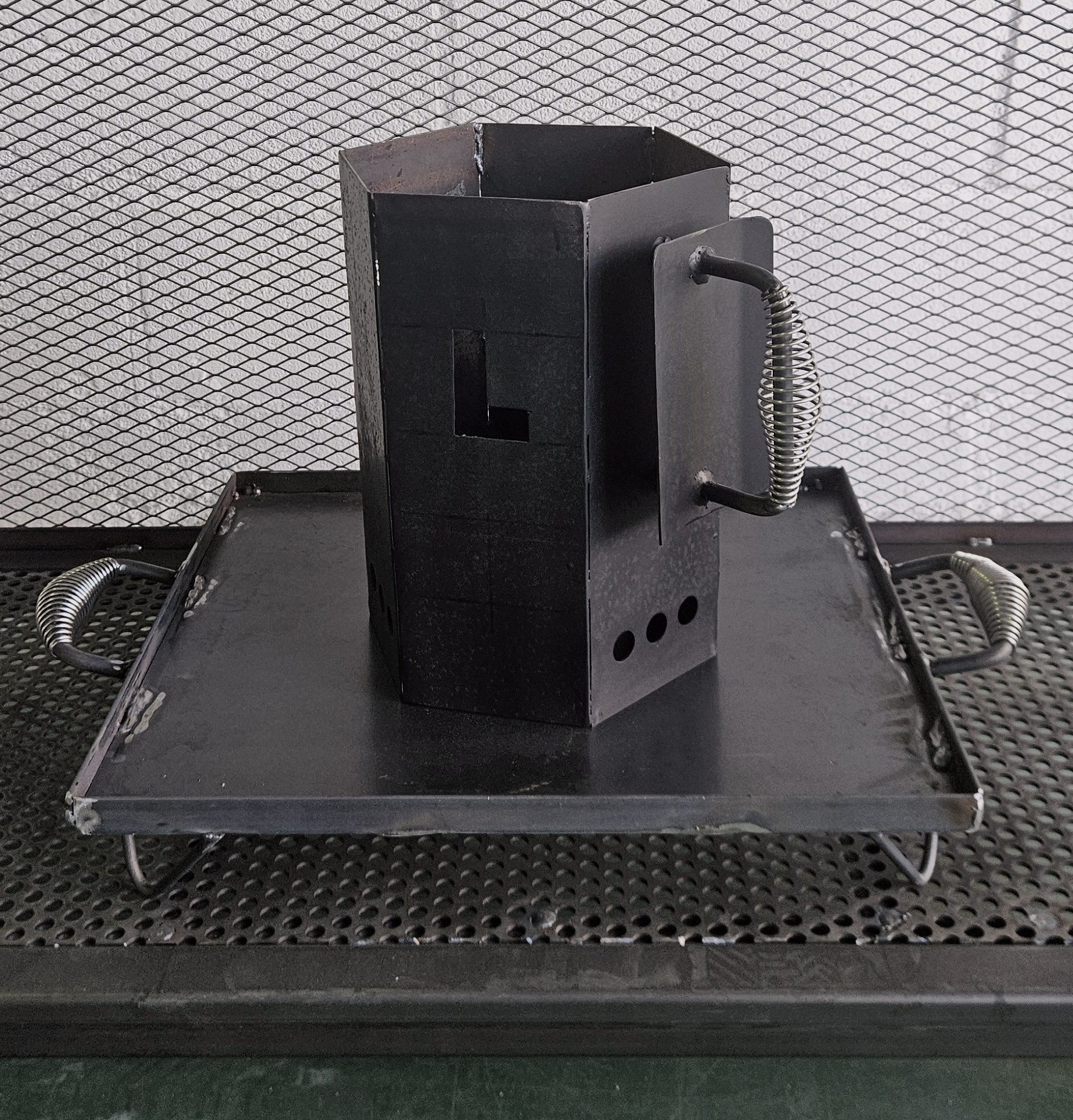 Encendedor de carbón hexagonal de acero al carbono sobre plataforma de acero